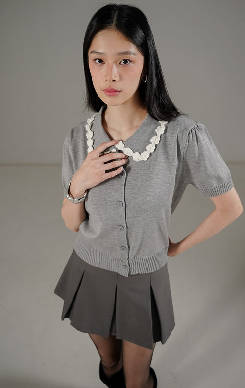 Arielle Cardigan Grey dari This Is April, cardigan rajut lengan pendek warna abu-abu dengan detail kerah bunga timbul 3D warna putih.