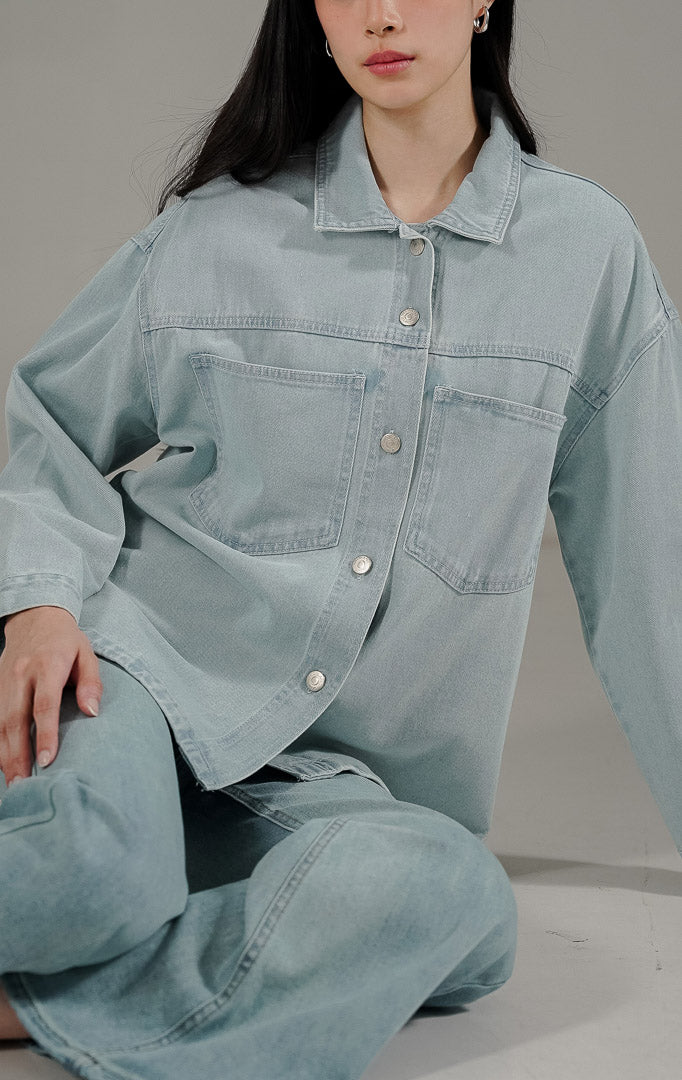 Beatrix Top Light Denim dari This Is April, kemeja denim wanita warna biru muda dengan dua saku dada aktif dan kancing metal perak.