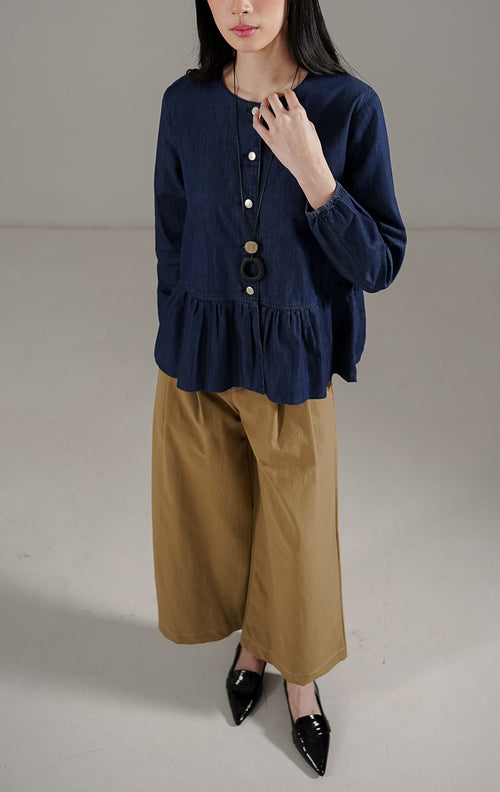 Deliana Top Indigo dari This Is April, blouse denim wanita lengan panjang warna indigo dengan detail kancing perak dan ruffle di bagian bawah.