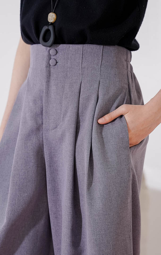 Celana panjang wanita This Is April Endellion Pants warna abu-abu, berbahan katun dengan potongan high-waist, detail dua kancing depan, lipit (pleats) rapi, dan karet pinggang di bagian belakang.