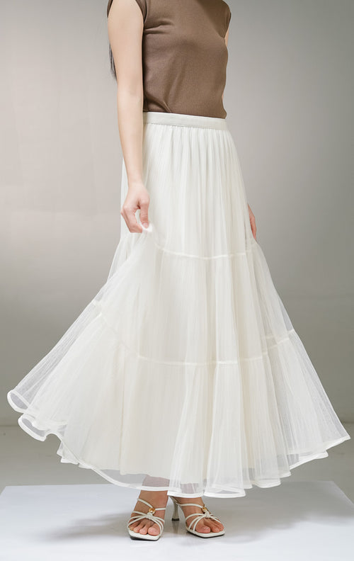 rok panjang wanita This Is April Gianella Skirt warna ivory (krem), model tiered maxi skirt dengan lapisan luar kain tile tulle transparan bertingkat dan furing dalam bertekstur plisket.
