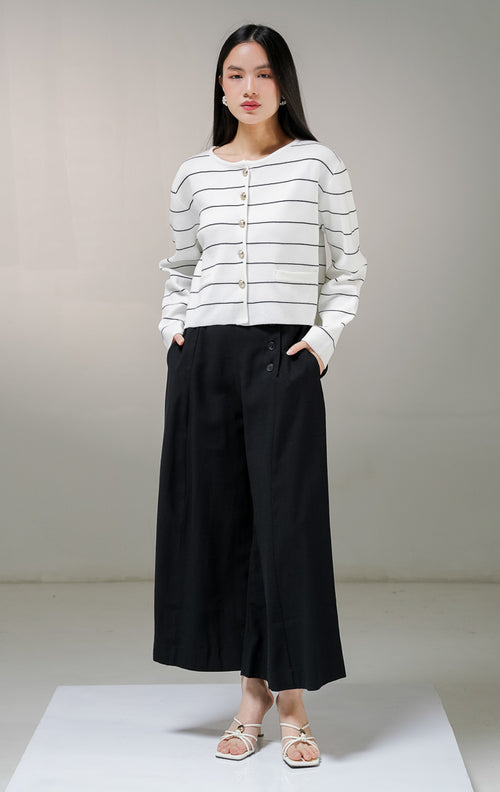 Kardigan rajut lengan panjang wanita This Is April Karleen Cardigan warna putih motif garis horisontal hitam, dengan kancing depan warna emas dan dua aksen kantong tiruan.