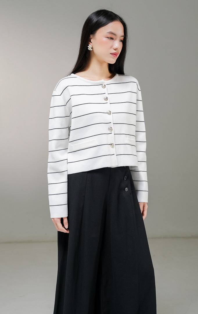 Kardigan rajut lengan panjang wanita This Is April Karleen Cardigan warna putih motif garis horisontal hitam, dengan kancing depan warna emas dan dua aksen kantong tiruan.