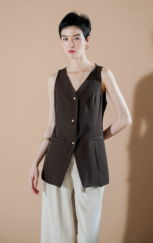 Laurence Vest Dark Brown dari This Is April, rompi panjang tanpa lengan wanita warna cokelat tua dengan detail kancing emas dan saku dekoratif