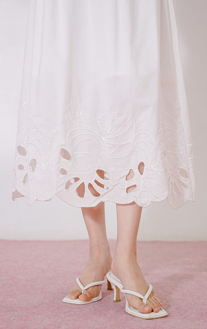 Rok panjang wanita This Is April Lilou Skirt warna putih, berpotongan longgar dengan full karet pinggang berkerut, dan detail bordir cut-out bermotif gelombang di sepanjang ujung bawah rok