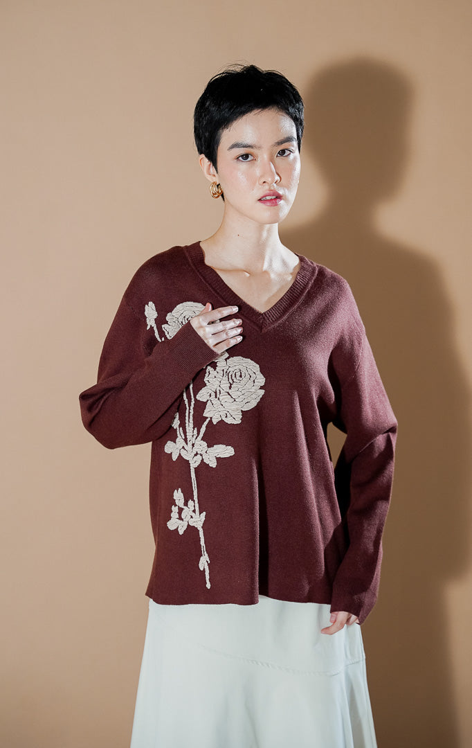 Lulie Sweater Brown dari This Is April, sweater rajut V-neck warna cokelat tua dengan detail bordir bunga mawar krem yang artistik di bagian depan.