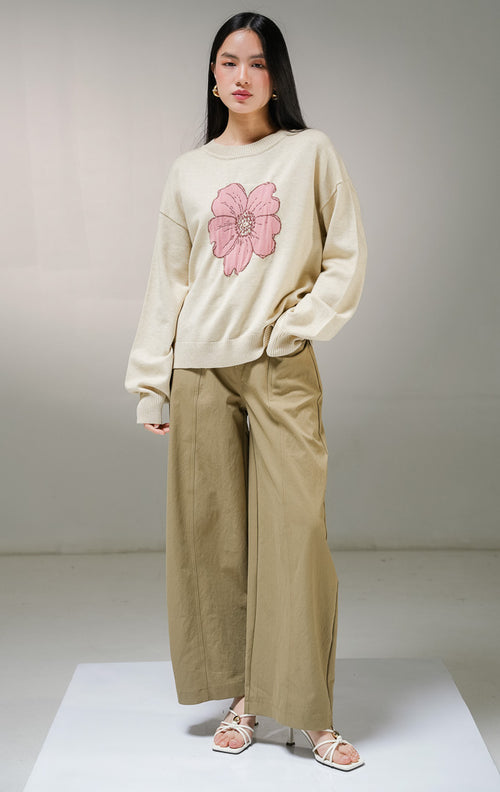 Atasan sweater rajut lengan panjang wanita This Is April Samantha Sweater warna cream, model kerah bulat dengan detail motif grafis bunga besar warna pink di bagian tengah depan.