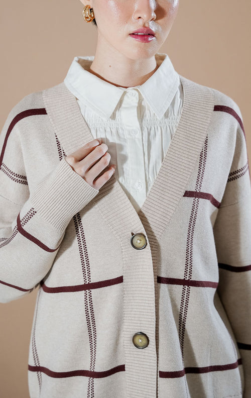 Thena Cardigan Khaki dari This Is April, cardigan rajut V-neck warna krem khaki dengan motif garis kotak-kotak cokelat marun dan kancing depan.