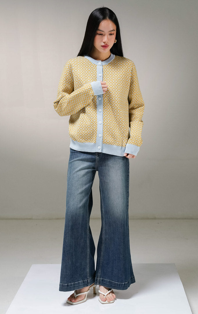 Kardigan rajut lengan panjang wanita This Is April Zayley Cardigan motif geometris warna kuning mustard, model kerah bulat dengan kancing depan dan tepian karet elastis warna biru muda.