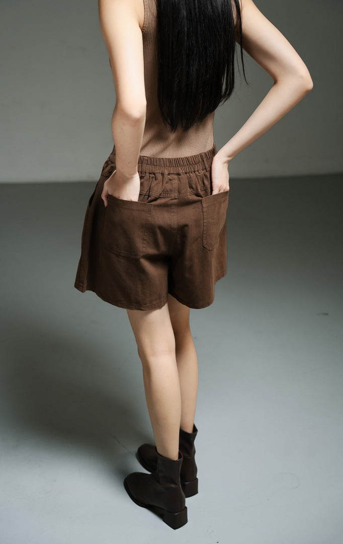 Celana pendek wanita model tailord bahan katun twill warna cokelat tua (dark brown utilitarian cotton twill shorts) Alden Pants dengan detail side-slant yang khas serta kenyamanan maksimal.