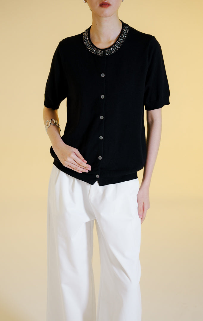 Pakaian wanita model atasan rajut cardigan lengan pendek dengan kancing depan dan hiasan permata di bagian kerah bulat (gemstone neckline short sleeve knit top) warna hitam Alveria Top untuk gaya kantor dan kasual anggun.