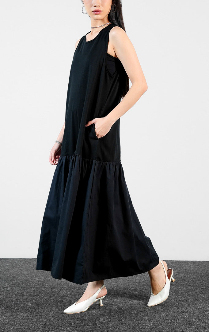 Pakaian wanita model terusan dress panjang tanpa lengan bahan katun warna hitam dengan detail rok kerut bertingkat (sleeveless flounce detail cotton dress) Alyona Dress untuk gaya kasual chic dan anggun.