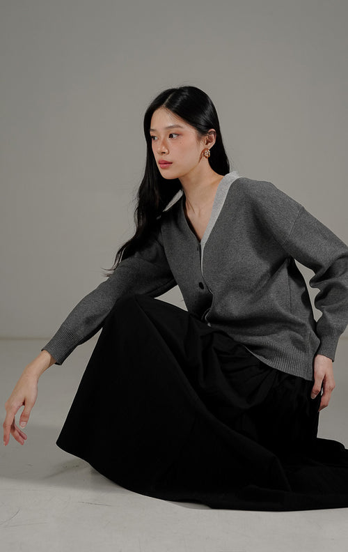 Blaise Cardigan Dark Grey dari This Is April, cardigan rajut V neck warna abu abu tua dengan kancing depan dan detail rib di ujung lengan.