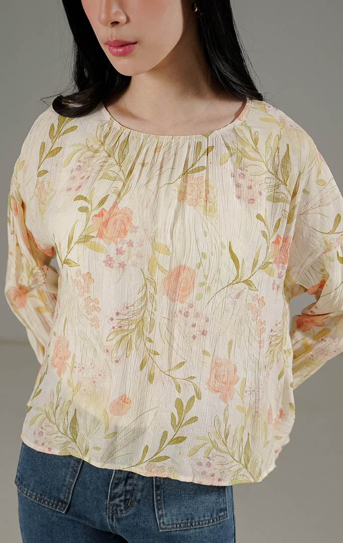 Cean Top Ivory dari This Is April, blus lengan panjang motif bunga (floral) warna putih ivory dengan detail ujung lengan tumpuk bervolume dan kancing belakang.