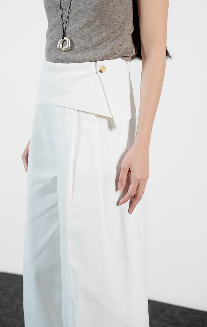 Bawahan wanita model celana panjang katun potongan lebar (white wide-leg pants) Christa Pants dengan detail pinggang lipat (fold-over waistband) yang struktural dan elegan.