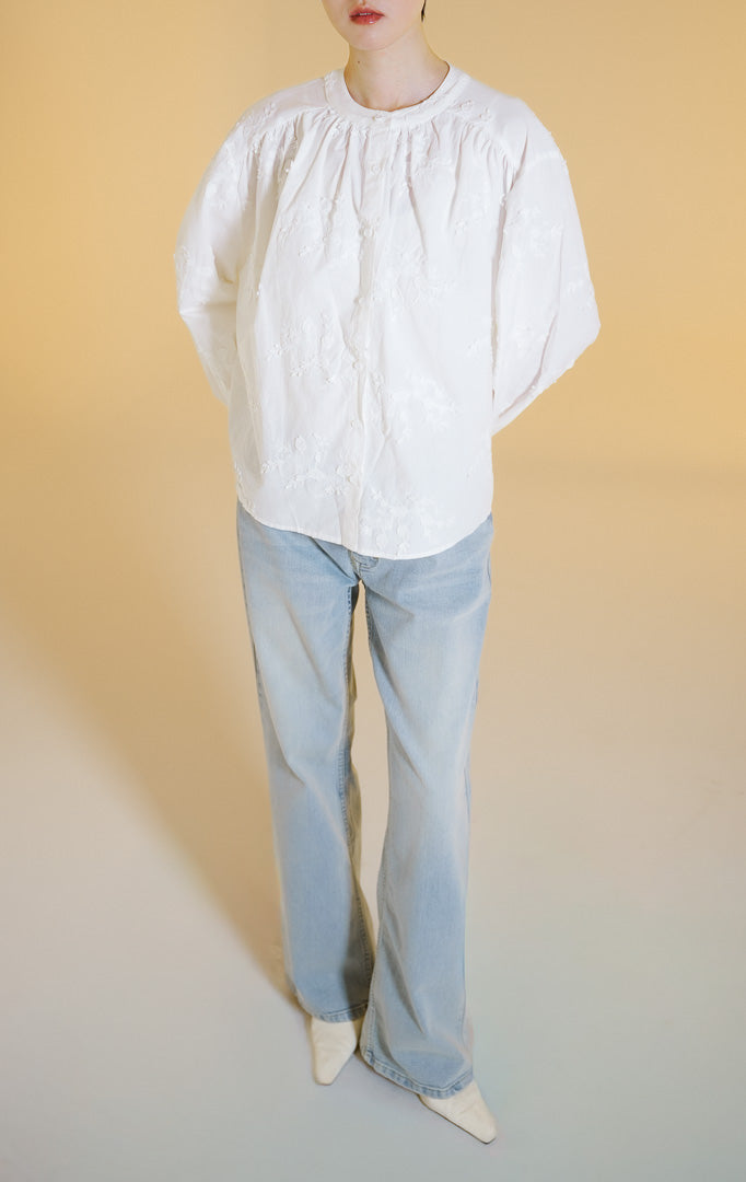 Pakaian wanita model blouse katun lengan panjang kerah bulat dengan detail bordir bunga (floral embroidered round neck top) warna putih Colette Top untuk gaya kasual anggun.