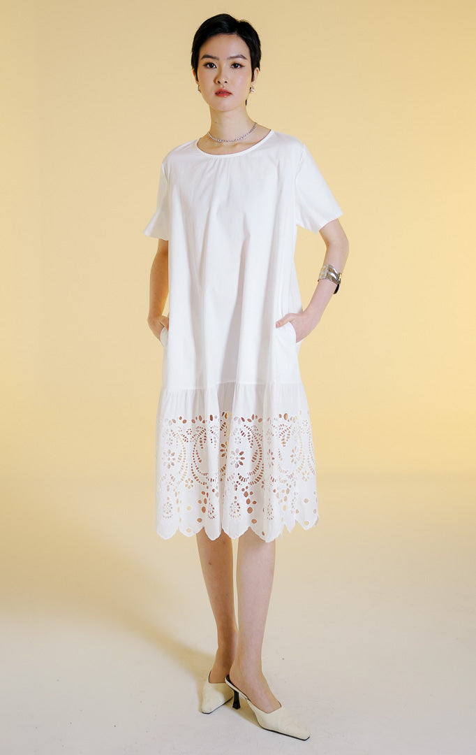 Pakaian wanita model gaun midi lengan pendek dengan detail bordir lubang bunga di bagian bawah (floral eyelet embroidered midi dress) warna putih Corrine Dress untuk gaya kasual anggun.