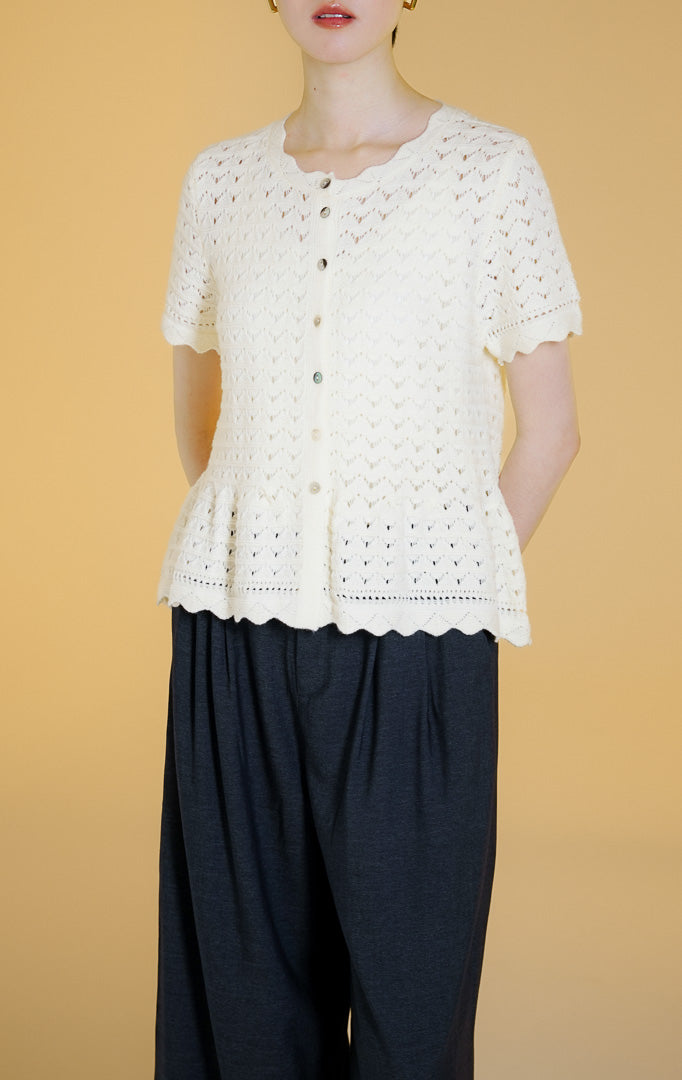 Pakaian wanita model atasan rajut cardigan lengan pendek kancing depan dengan motif kerawang crochet (pointelle crochet knit top) warna gading Cyralis Top untuk gaya kasual anggun.