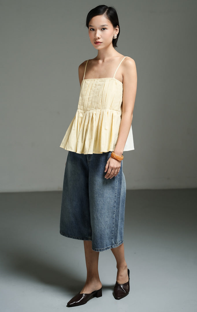 Atasan wanita tanpa lengan model camisole tali spaghetti warna kuning butter (butter yellow square pleated cami top) Dahliane Top dengan detail plisket rapi, kerah persegi, bahan campuran katun linen yang adem, serta panel elastis di bagian belakang.