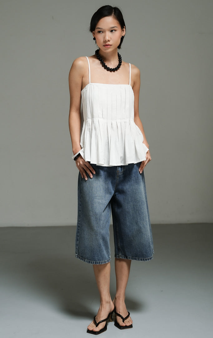 Atasan wanita tanpa lengan model camisole tali spaghetti warna putih (white square pleated cami top) Dahliane Top dengan detail plisket bertekstur, kerah persegi yang anggun, bahan katun linen yang breathable, serta bagian belakang karet yang nyaman.