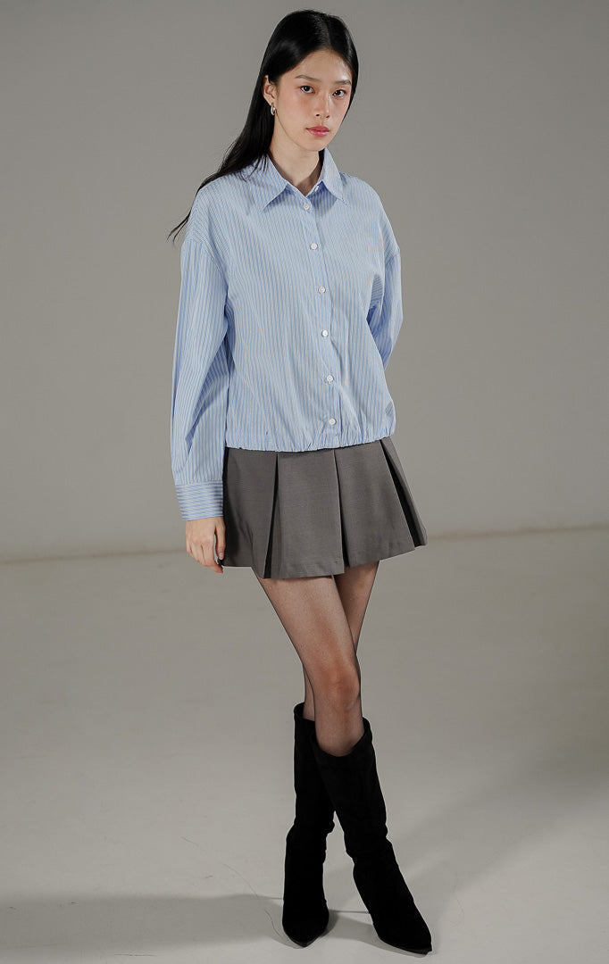Hailee Top Baby Blue dari This Is April, kemeja stripe biru putih dengan detail kerah, kancing depan, dan ujung bawah karet (elastic hem).