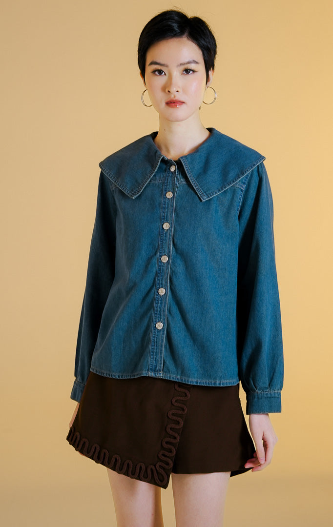 Pakaian wanita model kemeja jeans lengan panjang dengan kerah pelaut lebar dan kancing depan (sailor collar denim shirt) warna denim Ivelle Top untuk gaya kantor dan kasual anggun.
