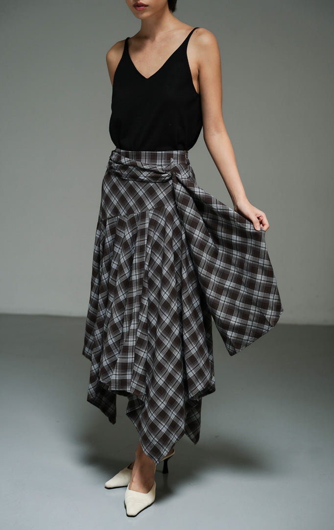 Rok panjang wanita model maxi bervolume motif kotak-kotak warna cokelat (brown dropped-waist plaid maxi skirt) Jaxen Skirt dengan potongan pinggang rendah yang unik serta siluet asimetris yang dinamis.