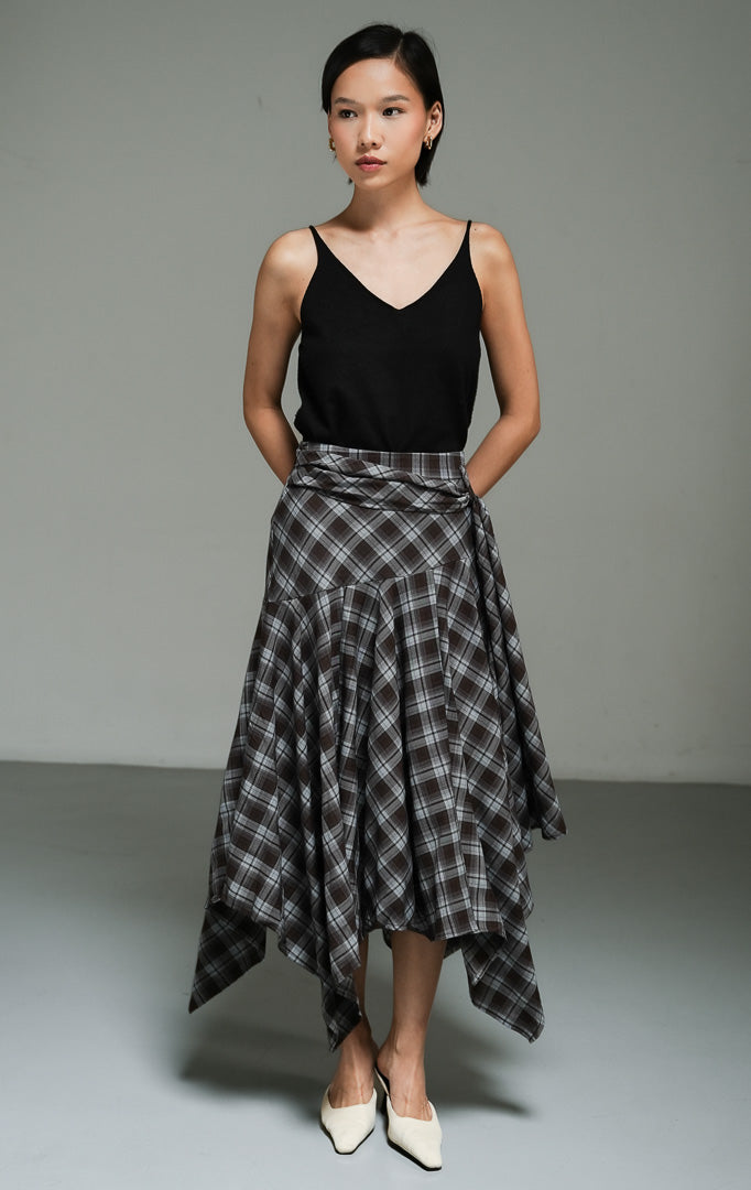 Rok panjang wanita model maxi bervolume motif kotak-kotak warna cokelat (brown dropped-waist plaid maxi skirt) Jaxen Skirt dengan potongan pinggang rendah yang unik serta siluet asimetris yang dinamis.