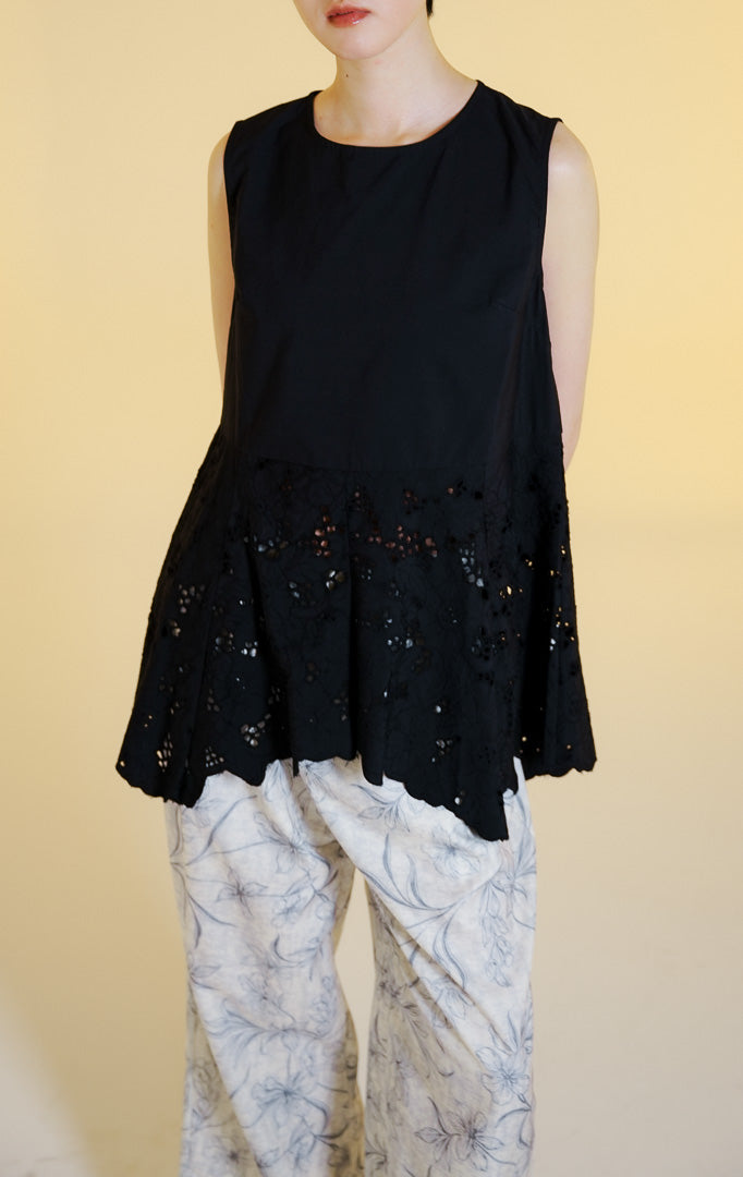 Pakaian wanita model atasan tanpa lengan bahan katun dengan potongan peplum dan bordir lubang bunga serta bagian bawah zig-zag (floral eyelet peplum sleeveless top) warna hitam Kareth Top untuk gaya kasual anggun.
