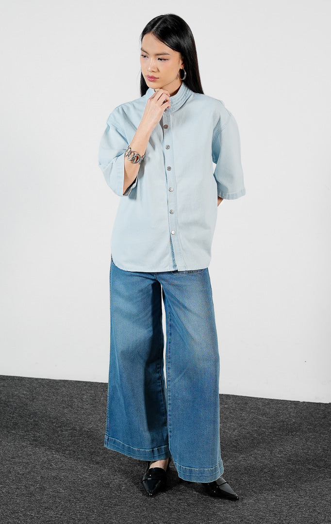 Pakaian wanita model kemeja denim lengan pendek warna biru muda dengan detail kerah quilting (quilted collar blouse) Maevelin Top untuk gaya kasual modern yang stylish.