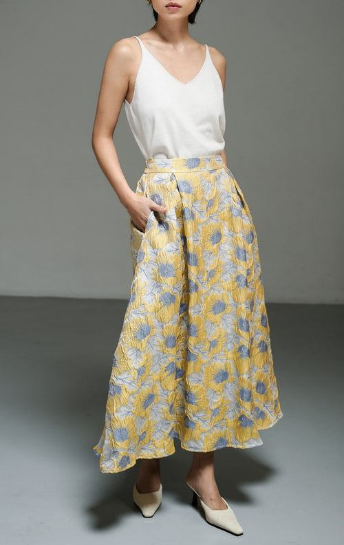Rok panjang wanita motif bunga dengan tekstur warna kuning (yellow floral print textured A-line skirt) Marella Skirt dengan siluet A-line yang anggun, bahan campuran katun poliester, serta pinggang elastis di bagian belakang.
