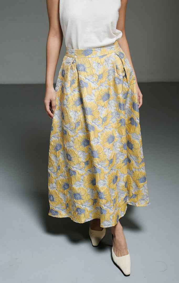 Rok panjang wanita motif bunga dengan tekstur warna kuning (yellow floral print textured A-line skirt) Marella Skirt dengan siluet A-line yang anggun, bahan campuran katun poliester, serta pinggang elastis di bagian belakang.