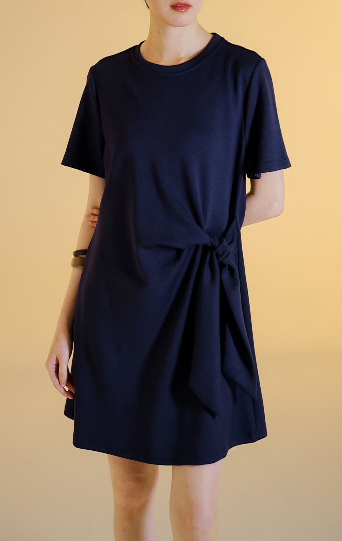 Pakaian wanita model gaun pendek terusan lengan pendek berkerah bulat dengan aksen simpul ikatan di samping (side-knot scuba mini dress) warna navy Merily Dress untuk gaya kantor dan kasual anggun.