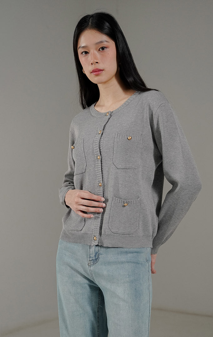 Meriya Cardigan Grey dari This Is April, cardigan rajut lengan panjang warna abu abu dengan detail 4 saku depan dan kancing emas yang elegan.