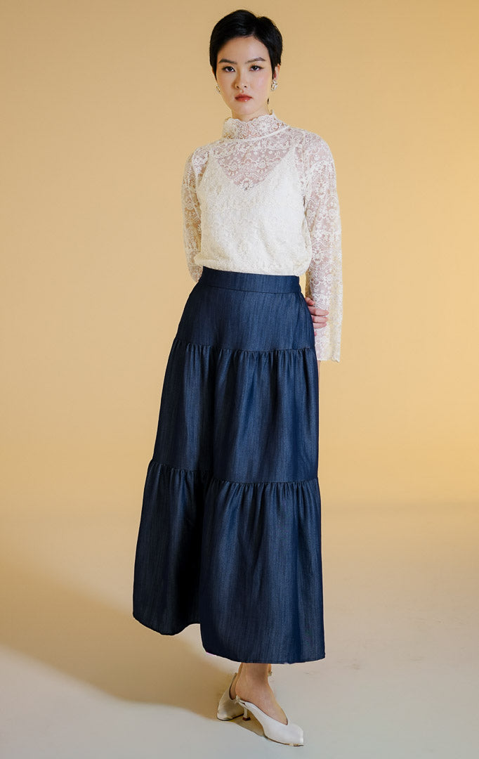 Pakaian wanita model rok panjang maxi bertingkat bahan jeans (tiered denim maxi skirt) warna dark denim Morita Skirt untuk gaya kantor dan kasual anggun.