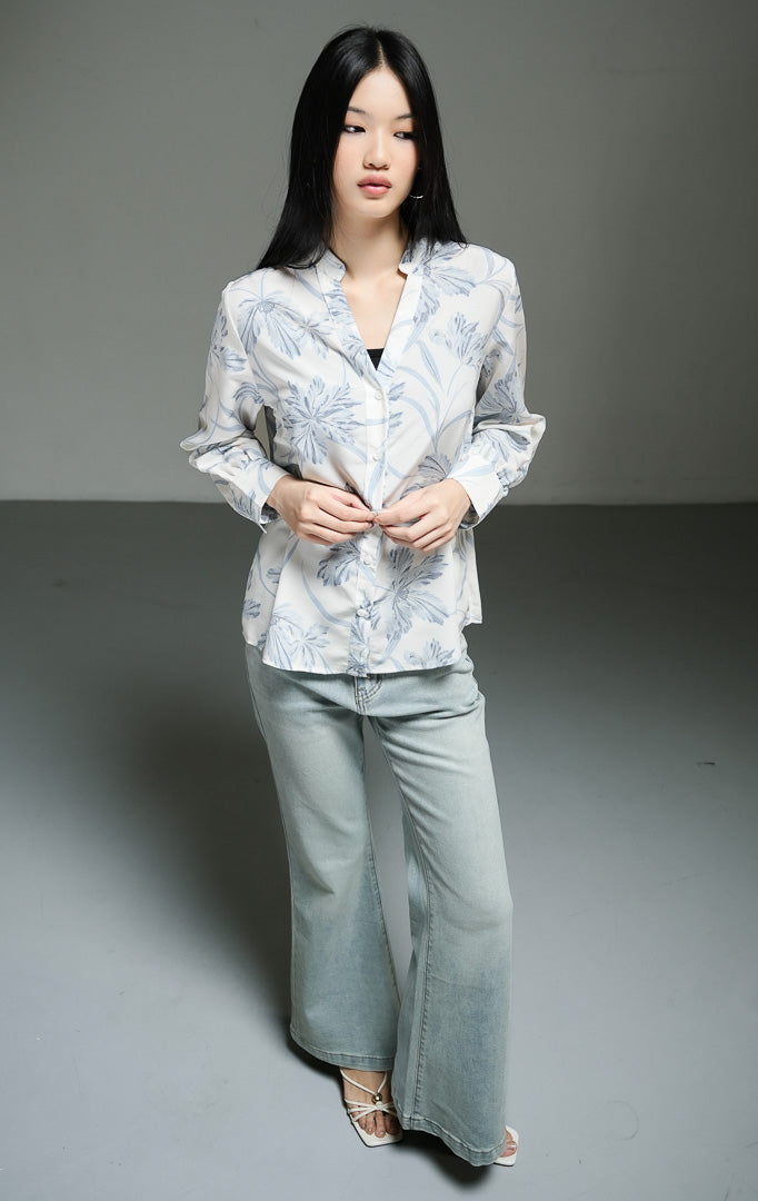 Kemeja wanita lengan panjang motif bunga warna biru muda (light blue floral print split collar top) Morven Top dengan detail kerah V belah, bahan poliester ringan bertekstur jatuh, serta kancing depan klasik.
