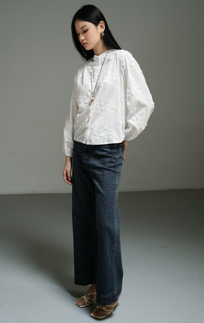 Blus wanita lengan panjang warna putih (white leaf embroidered cotton blouse) Nerine Top dengan detail bordir daun yang halus, bahan katun berkualitas non-stretch yang berstruktur, serta kancing depan klasik.