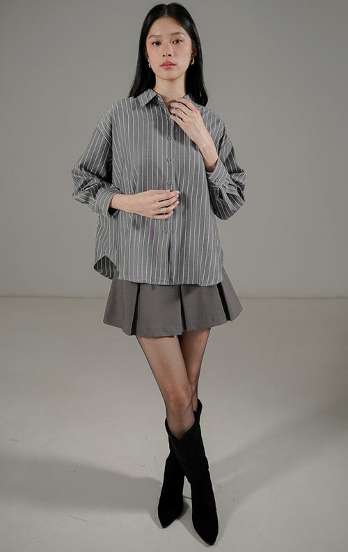 Nerisse Top Dark Grey dari This Is April, kemeja kancing depan motif salur vertikal abu abu tua dengan potongan bahu turun.