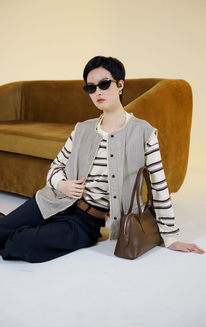 Pakaian rompi wanita tanpa lengan bahan katun berkerah bulat dengan kancing depan dan detail pinggiran serabut (raw edge trim cotton vest) warna khaki Noralise Vest untuk gaya kantor dan kasual anggun.