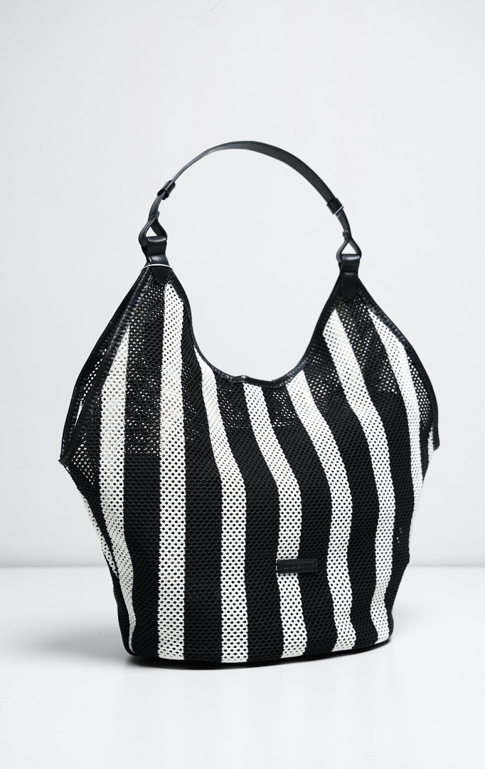 Tas wanita model hobo bag bahan rajut jaring motif garis warna hitam dan putih (black striped open-knit mesh hobo bag) Odessa Bag dengan detail tali pegangan yang nyaman dan elegan.