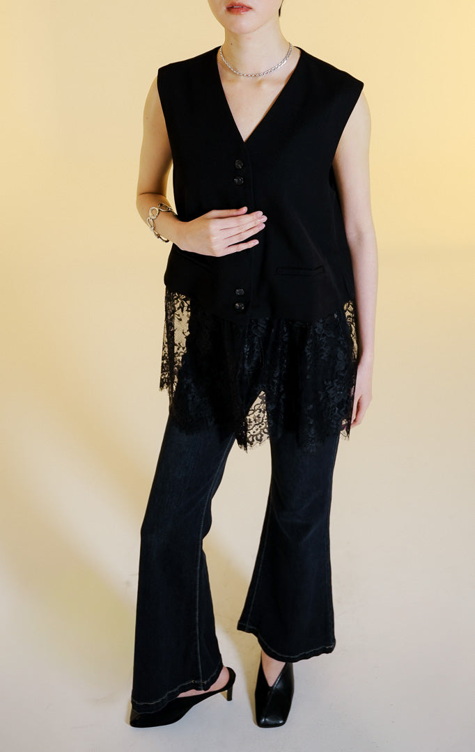 Pakaian rompi wanita tanpa lengan kerah V kancing depan dengan aksen renda bunga transparan di bagian bawah (floral lace hem vest) warna hitam Orvella Vest untuk gaya kantor dan kasual anggun.