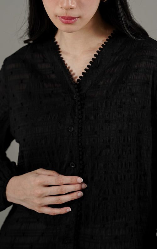 Palmer Top Black dari This Is April, blus lengan panjang warna hitam bahan sheer menerawang dengan detail bordir benang timbul dan kerah V.