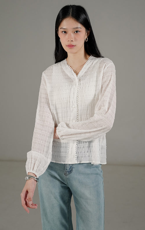 Palmer Top White dari This Is April, blus lengan panjang wanita warna putih bahan sheer transparan dengan detail bordir benang timbul dan kerah V.