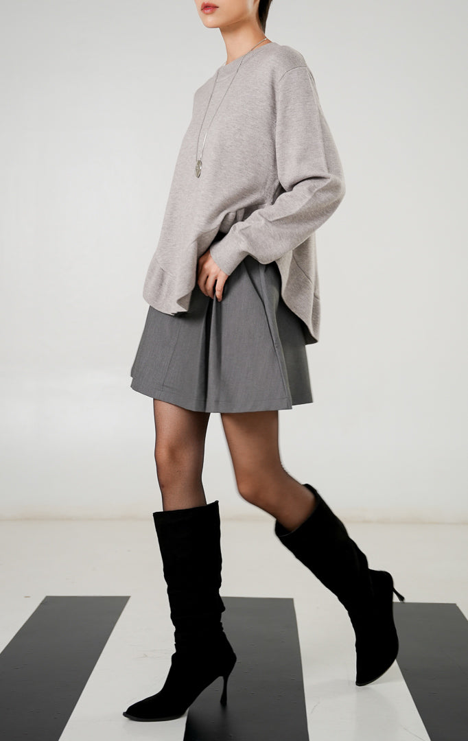 Sweater rajut wanita lengan panjang warna abu abu muda (light grey) dengan detail hem ruffle bergelombang di bagian bawah dari This Is April.