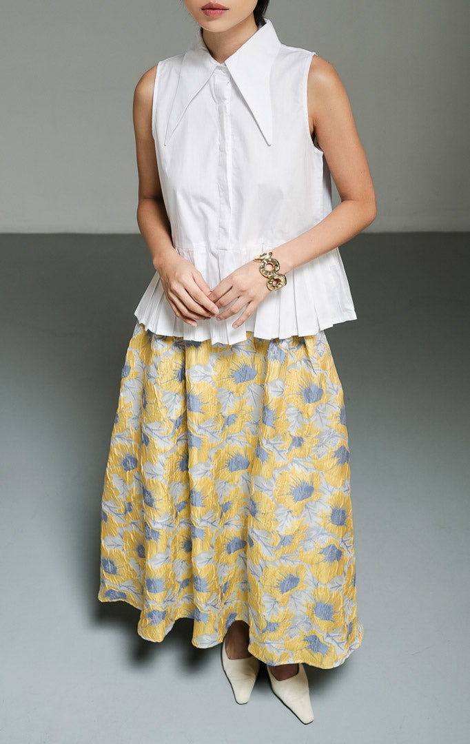 Atasan wanita tanpa lengan model peplum bervolume (exaggerated peplum top) warna putih (white) Serelina Top dari bahan katun poplin terstruktur dengan desain siluet struktural yang chic.