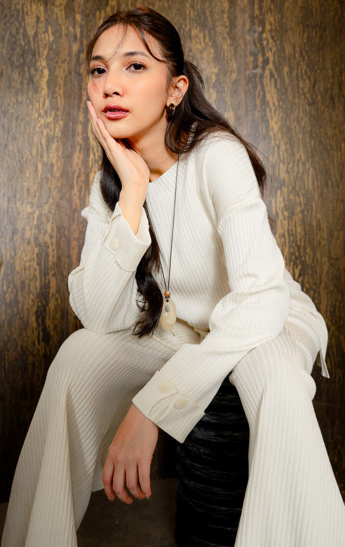 Pakaian atasan wanita model sweter rajut panjang (longline knit sweater) bertekstur ribbed lembut dan elastis dilengkapi belahan samping (side split) warna ivory SF Arosa Sweater untuk gaya kantor dan harian anggun.