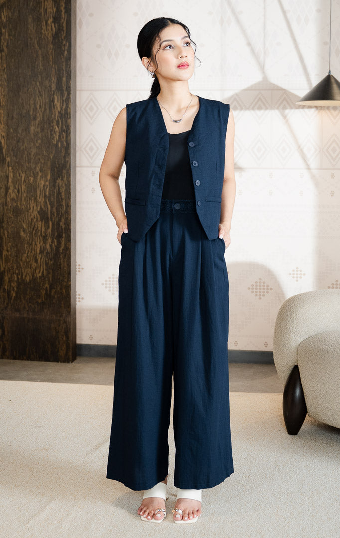 Pakaian bawahan wanita model celana panjang flowy longgar (semi-pleated flowy pants) dengan detail pinggang renda motif bunga (floral lace waistband) warna navy SF Charlotta Pants untuk gaya kantor dan kasual anggun.