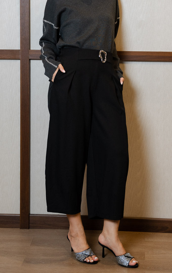 Pakaian bawahan wanita model celana panjang potongan lebar melengkung (barrel leg pants) dengan aksen gesper logam di pinggang (metal buckle waistband) warna hitam SF Cordelia Pants untuk gaya kantor dan kasual anggun.