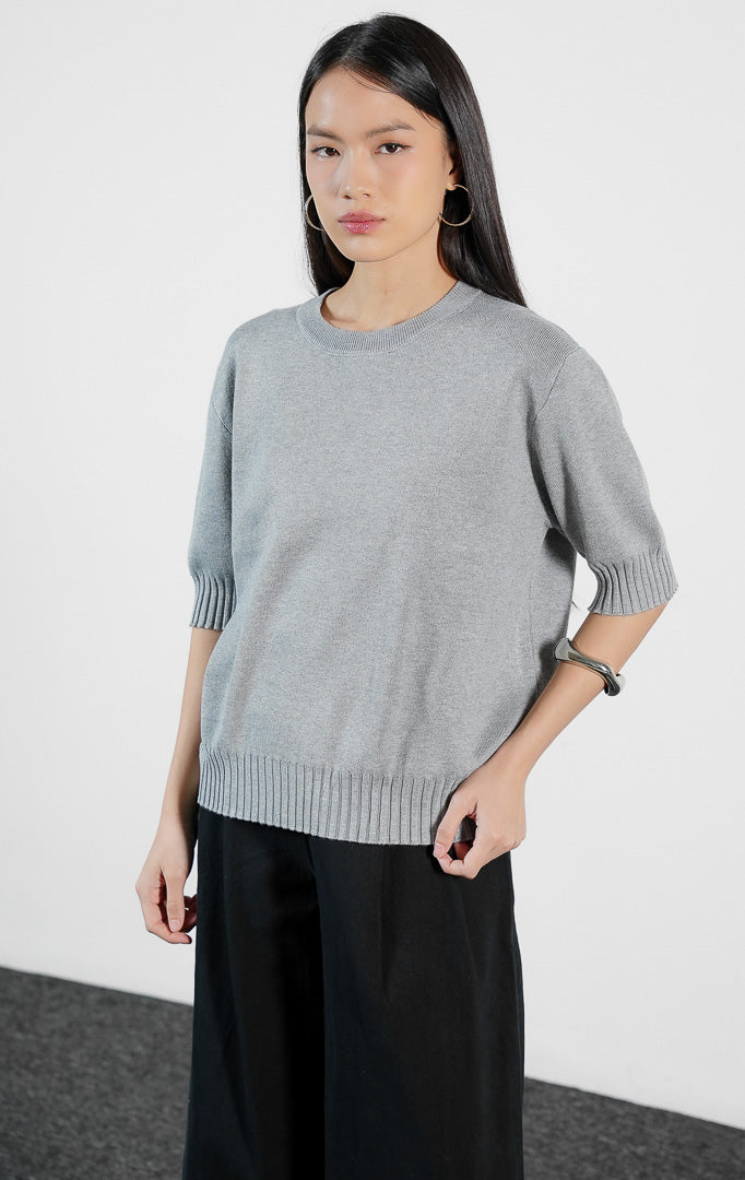 Pakaian wanita model atasan rajut lengan pendek dengan detail ujung lengan dan bawah bertekstur rib (ribbed cuff knit top) warna abu-abu Vernell Top untuk gaya kasual elegan.