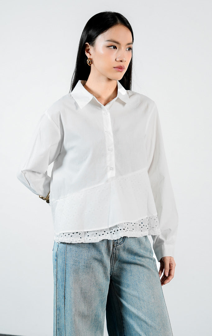 Pakaian wanita model kemeja katun lengan panjang dengan detail bordir lubang pada bagian bawah peplum (eyelet broderie peplum shirt) warna putih Yoren Top untuk gaya kasual elegan yang chic.